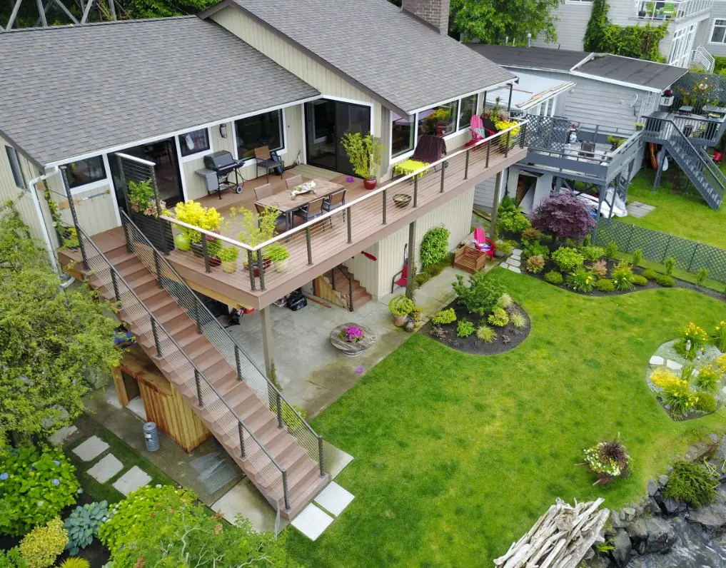 Elevated residential backyard deck with cable railings and stairs